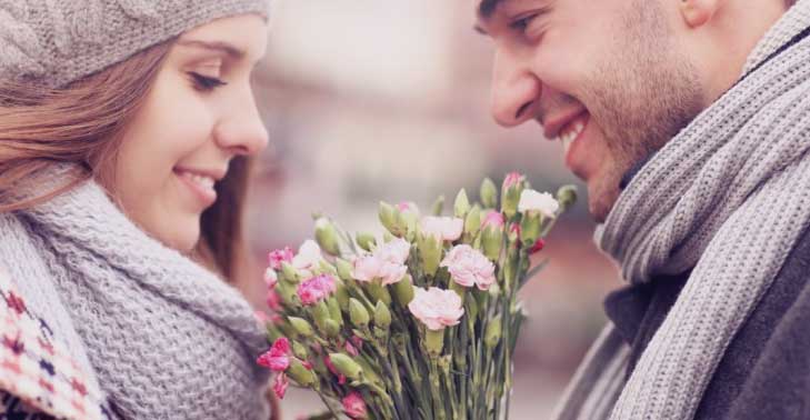 Devo esperar o ex pedir para voltar ou devo pedir logo? Na imagem, um homem oferece um buquê de flores para uma mulher.