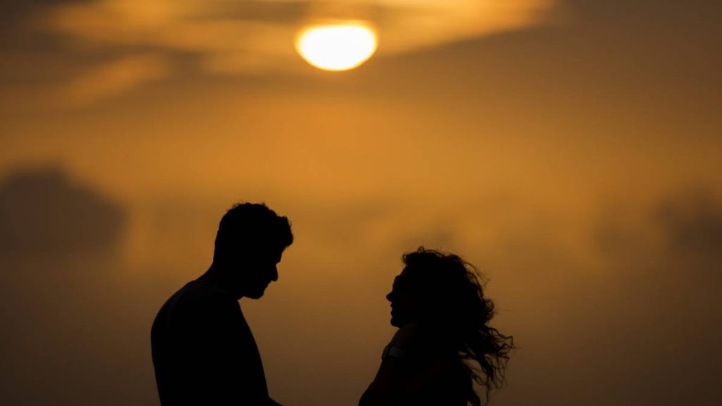 Reconquistar diariamente para ser felizes para sempre. Na imagem: a silhueta de um casal ao pôr do sol.