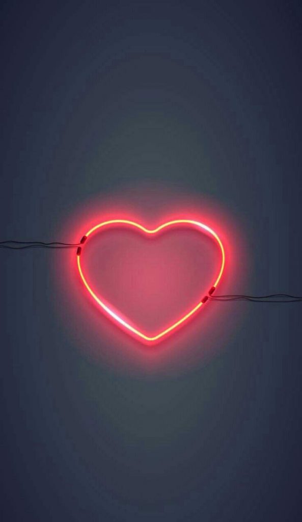 O amor realmente suporta tudo? Na imagem: Um coração em iluminação neon vermelho.