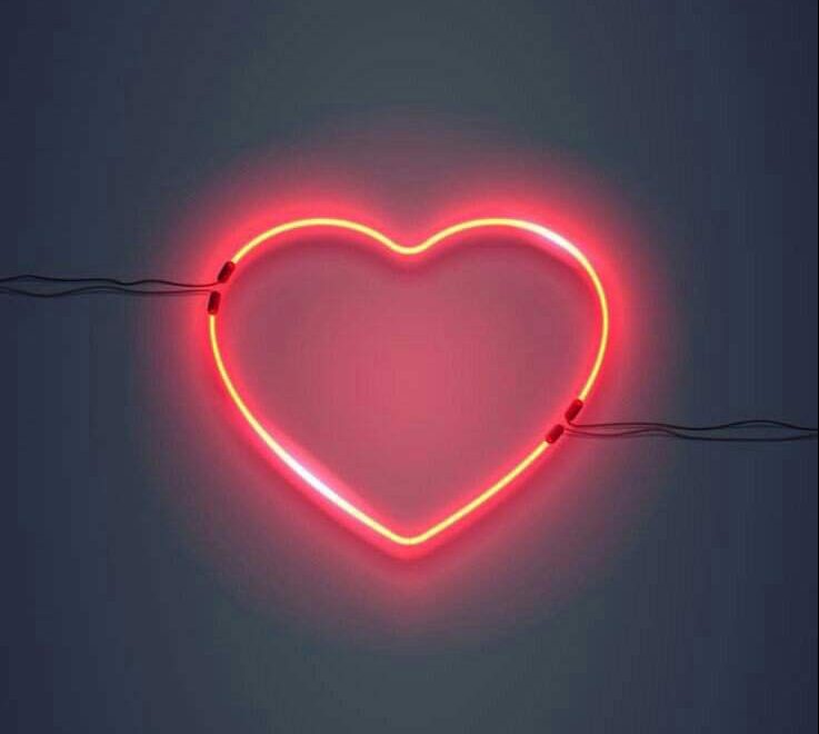 O amor realmente suporta tudo? Na imagem: Um coração em iluminação neon vermelho.