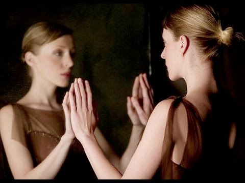 Como aplicar a técnica do espelho na reconquista? Na imagem: mulher branca e loira encara a si mesma no espelho.