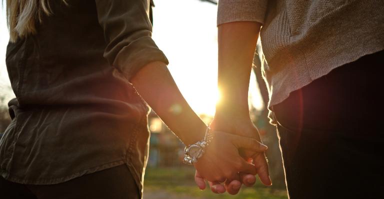 Amor e paixão nos relacionamentos. Na imagem: Um casal de mãos de dadas.
