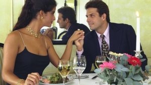 Na imagem: casal flerta durante um encontro, você é confiante na hora da paquera?
